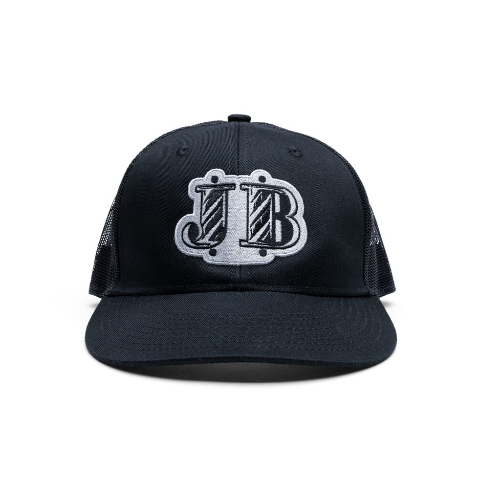 Johnny B. dark gray trucker hat. Johnny B. logo patchwork is stitched in white.