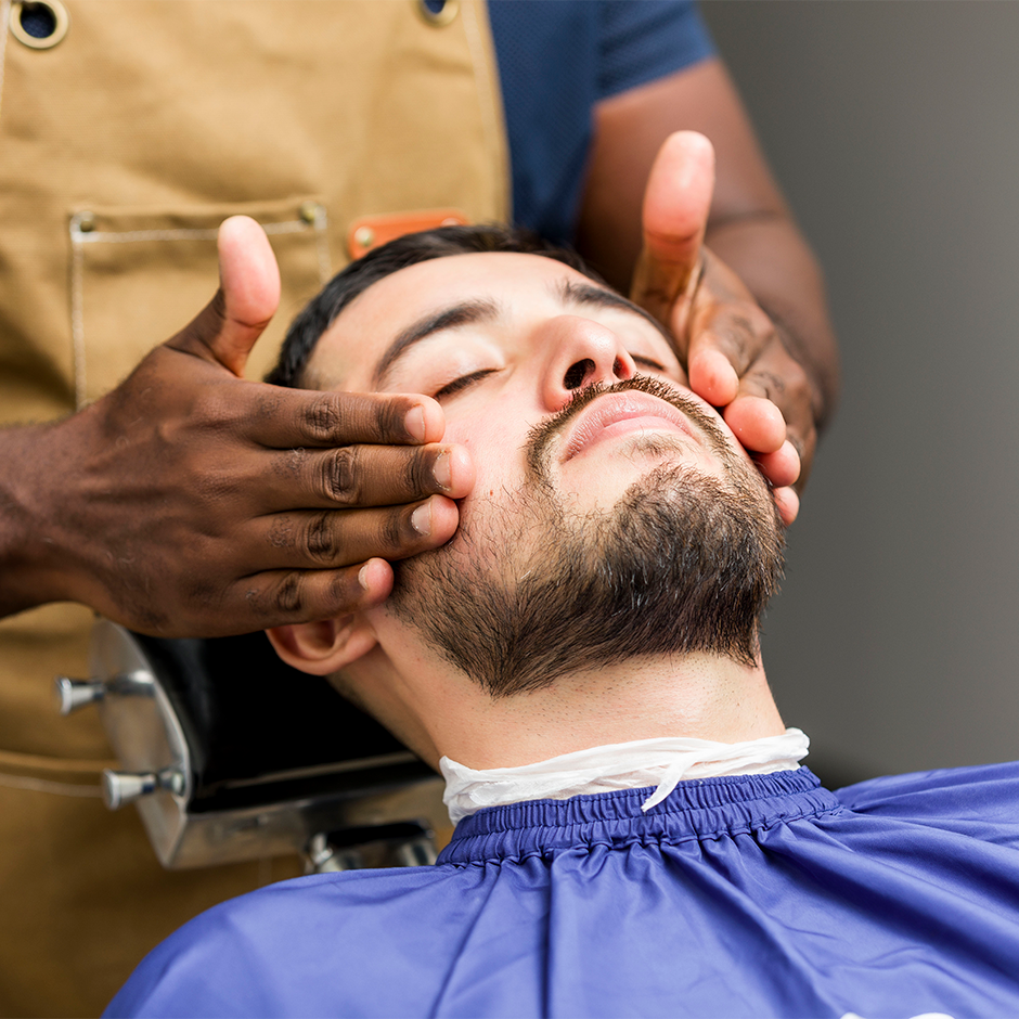 Barber shaving clients beard