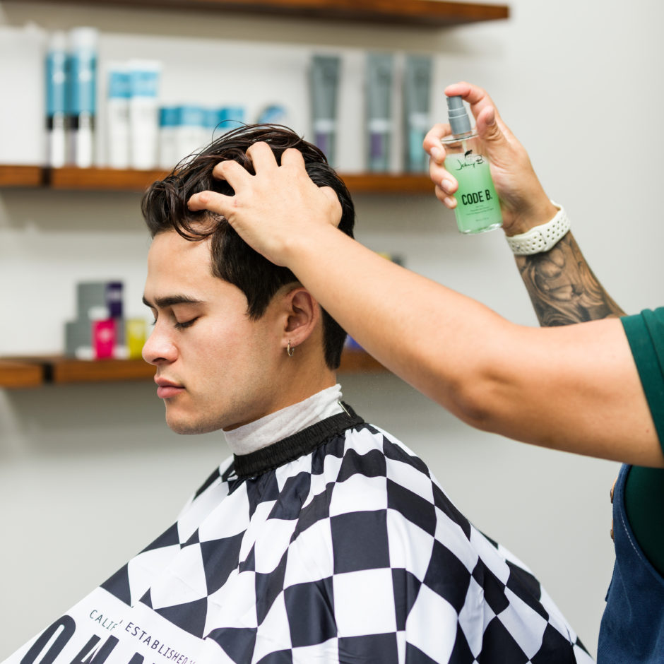 Barber spraying Code B. in customer hair