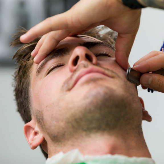 Four Step Shaving Method. Customer getting beard shaved.